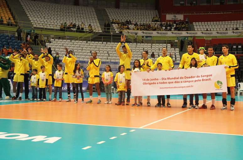 Equipe maculina entra em quadra com faixa saudando doadores de todo o mundo