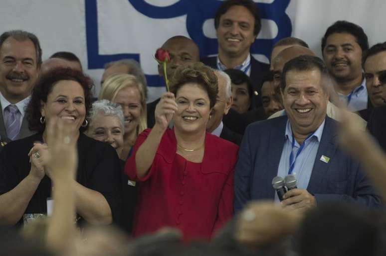 Dilma segura rosa vermelha, símbolo do partido
