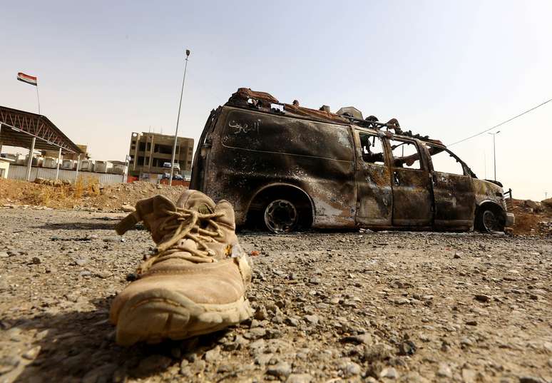 <p>Veículo queimado pertencente a forças de segurança iraquianas é retratado em um posto de controle no leste de Mossul, um dia depois de insurgentes sunitas radicais tomarem o controle da cidade, em 11 de junho</p>