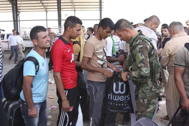 <p>Membros das froças de segurança do Iraque e do Curdistão revistam iraquianos que fogem da violência na cidade de Mossul, em 10 de junho</p>