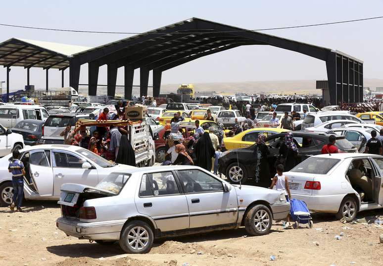 <p>Famílias que fogem da violência na cidade iraquiana de Mossul chegam a um posto de controle na periferia de Arbil, na região do Curdistão do Iraque, em 10 de junho</p>