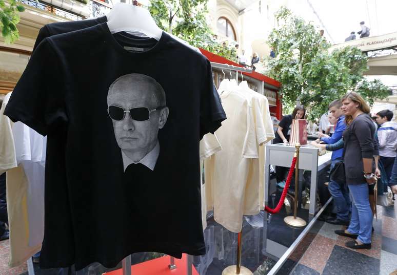 <p>Camisetas com imagem do presidente da Rússia, Vladimir Putin, à venda em uma loja de departamentos no centro de Moscou, em 11 de junho. As camisetas foram inspiradas por triunfos de atletas russos nos Jogos Olímpicos e Paraolímpicos de Inverno Sochi 2014</p>