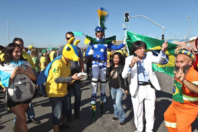 A abertura da Copa do Mundo transformou a Arena Corinthians em um verdadeiro Carnaval. O animador de festas Jonathan Scorpion (ao centro) se vestiu de Mr. Copa com um penacho verde e amarelo e pernas de mola. Ao lado dele, um torcedor se fantasiou de Fuleco para apoiar o Brasil 