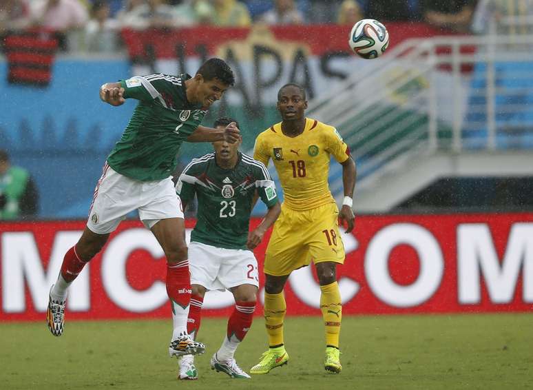 <p>Francisco Rodriguez e Vazquez, do México, dividem bola aérea com Eyong, de Camarões durante jogo na Arena das Dunas, em Natal</p>