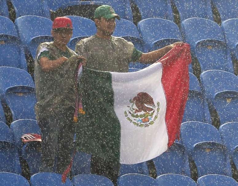 <p>Apesar de chuva forte e persistente, torcida mexicana não desanima na Arena das Dunas, em Natal. Camisas, bandeiras, sombreros e máscaras de Lucha Libre foram combinadas a capas de chuva. A seleção mexicana faz sua estreia no Mundial de 2014 contra o Camarões</p>