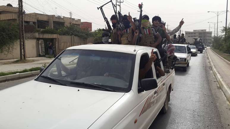 <p>Militantes do EIIL celebram em veículos tomados do exército iraquiano a tomada de cidades no país</p>