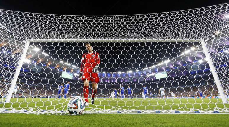 Goleiro da Bósnia volta para pegar a bola dentro da rede no gol argentino