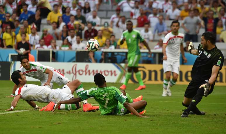 <p>O goleiro Alireza protege a meta iraniana do atacante nigeriano Ahmed Musa. Jogando na Arena da Baixada, em Curitiba, Irã e Nigéria fizeram um jogo fraco tecnicamente, ficaram no 0 a 0 e registraram o primeiro empate do Mundial deste ano.</p>