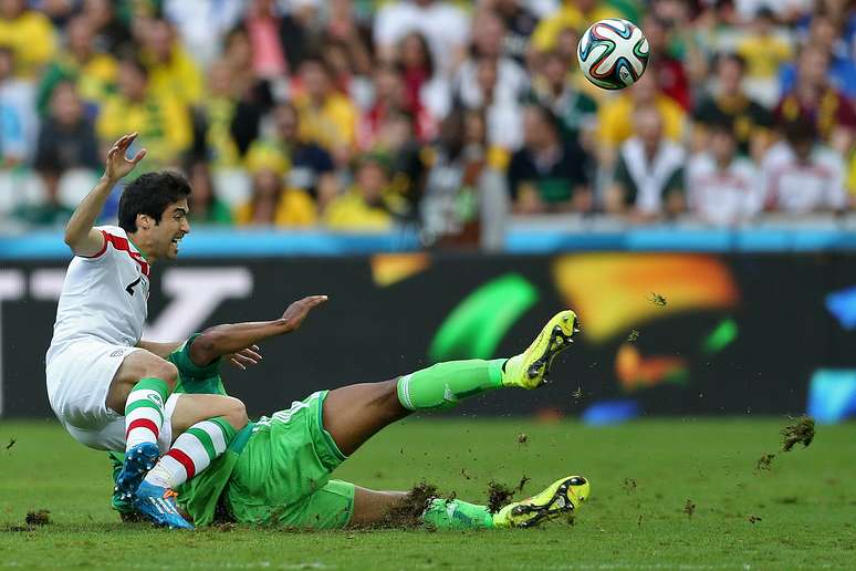 Zagueiro do Irã Khosro Heidari briga pela bola com o meia nigeirano John Obi Mikel