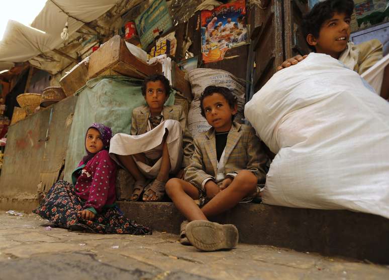 <p>Crian&ccedil;as sentadas&nbsp;em um mercado na cidade velha de Sanaa, no I&ecirc;men, em 17 de junho</p>