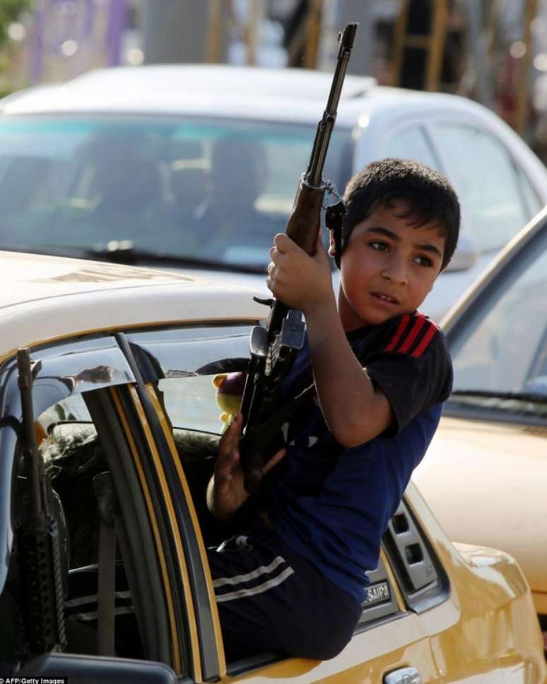 <p>Criança exibe arma em carro no Iraque</p>