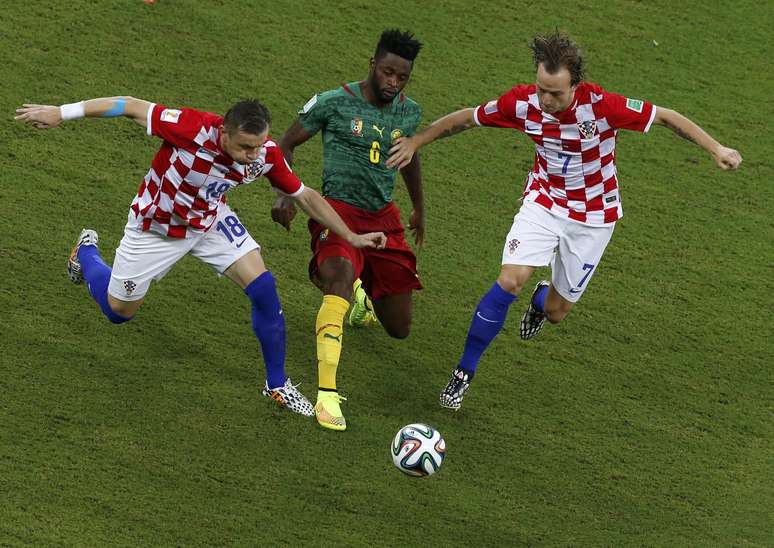 Song disputa bola com Rakitic e Olic em partida entre Croácia e Camarões, válida pelo Grupo A
