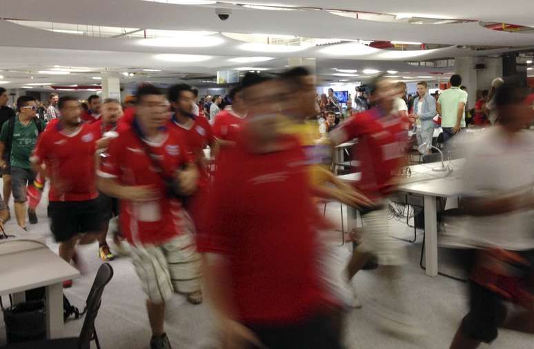 <p>Torcedores chilenos correm pela sala de imprensa do Maracanã durante invasão do local antes do jogo contra a Espanha.</p>