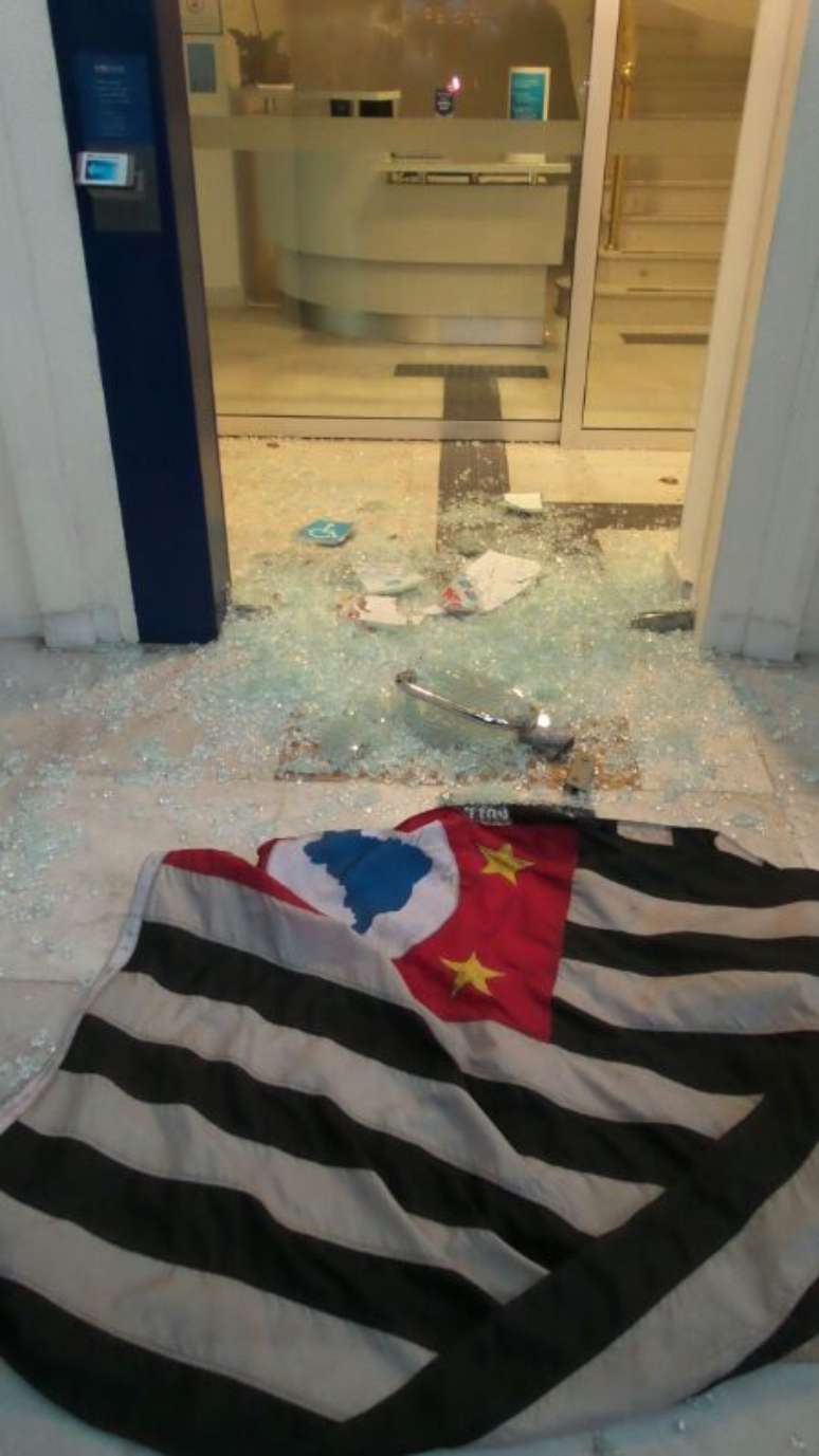 <p>Bandeira de São Paulo é jogada em meio a cacos de porta de vidro de agência do Citibank</p>