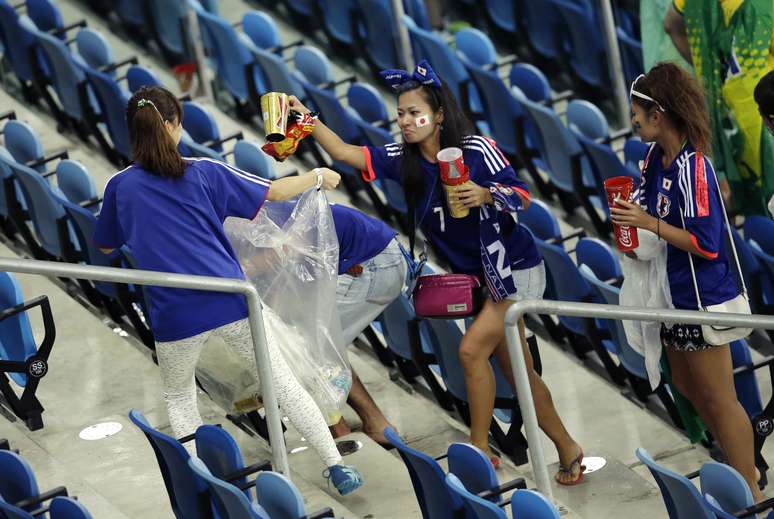 Torcedores do Japão recolhem lixo na Arena das Dunas, em Natal, depois de partida contra a Grécia, pelo Grupo C