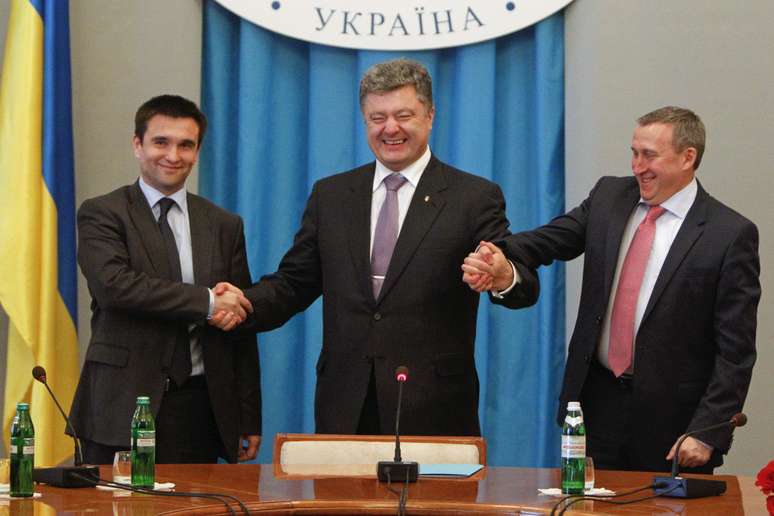 <p>Petro Poroshenko aperta a m&atilde;o do rec&eacute;m-nomeado ministro das Rela&ccedil;&otilde;es Exteriores, Pavlo Klimkin (&agrave; esq.) e do ex-ministro das Rela&ccedil;&otilde;es Exteriores, Andriy Deshchytsia</p>