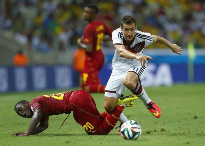 Miroslav Klose, da Alemanha, disputa a bola com jogadores de Gana durante jogo em Fortaleza. 21/06/2014.