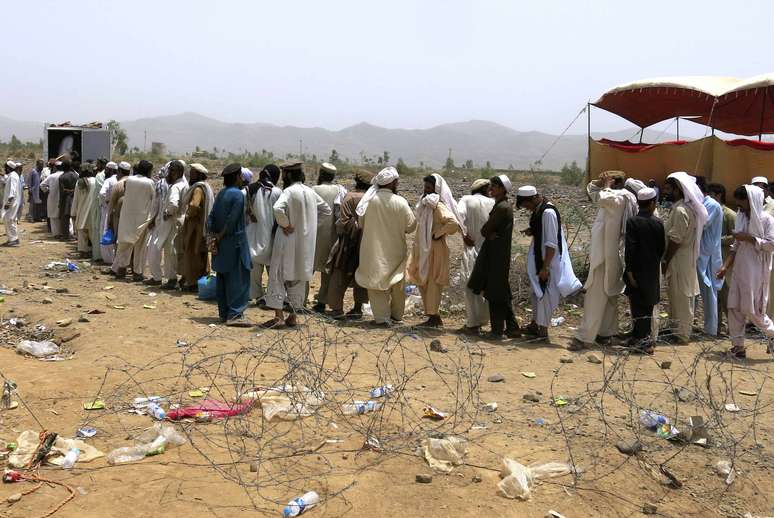 <p>Pessoas, que fugiram da ofensiva militar contra militantes paquistaneses fazem fila para receber abastecimento alimentar do ex&eacute;rcito</p>