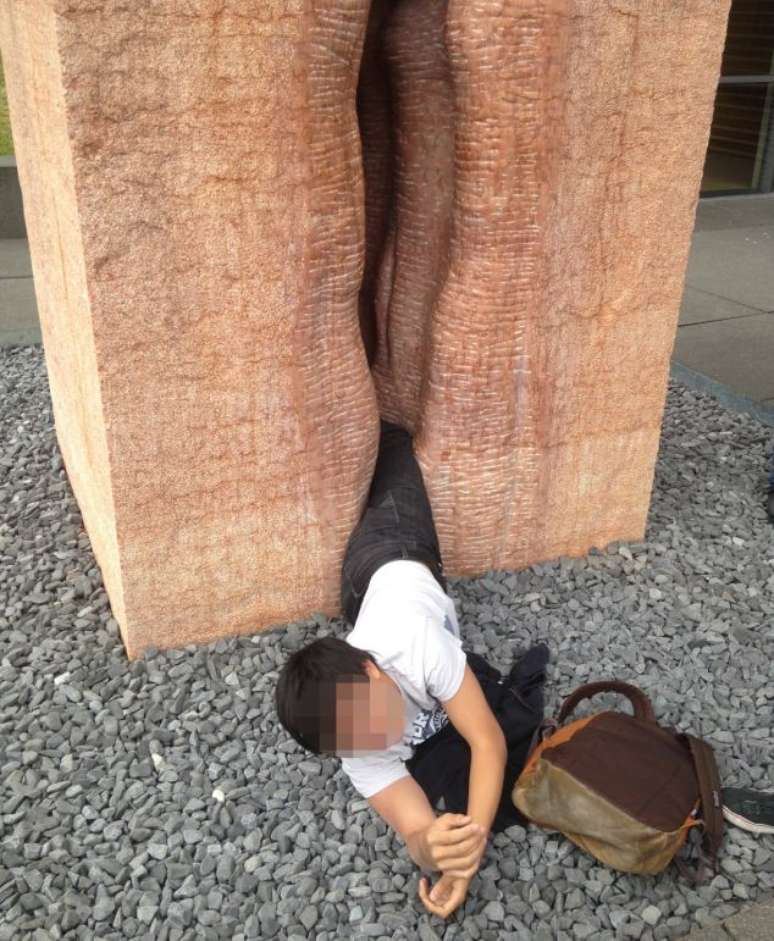 <p>Estudante escorregou e ficou com as pernas presas em uma parte estreita da escultura</p>