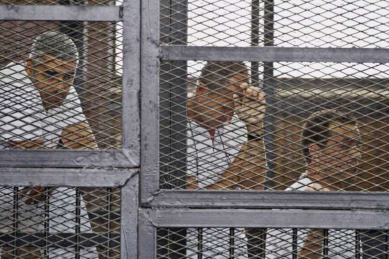 <p>Jornalistas da Al-Jazeera&nbsp;s&atilde;o fotografados dentro de uma cela durante &nbsp;seu julgamento por acusa&ccedil;&otilde;es de terrorismo em um tribunal no Cairo, em&nbsp;15 de maio</p>