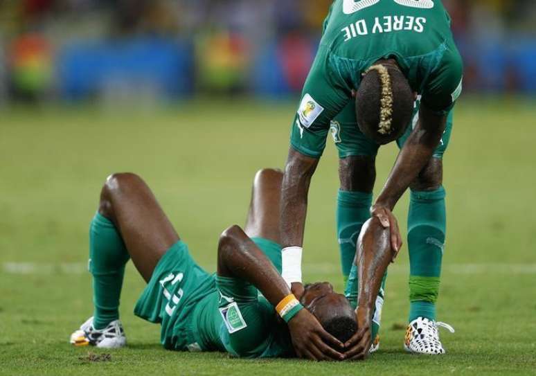 O jogador da Costa do Marfim Geoffroy Serey Die (d) consola o colega de time Giovanni Sio após a derrota para a Grécia em jogo da Copa do Mundo, na arena Castelão, em Fortaleza, nesta terça-feira. 24/06/2014