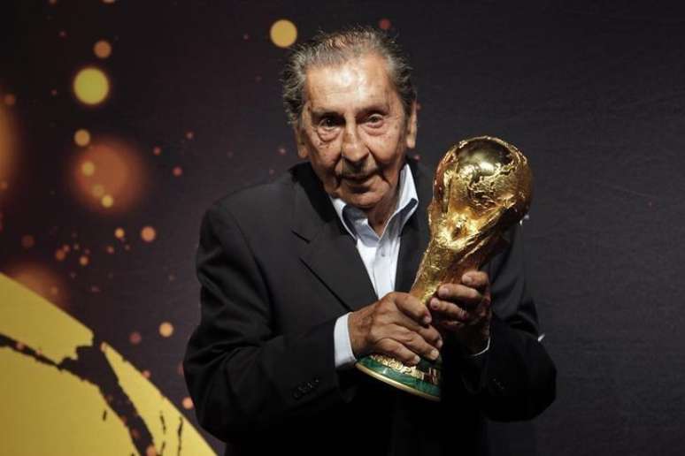 Ex-jogador uruguaio Alcides Ghiggia, famoso por sua atuação na final do Mundial de 1950, posa para foto com a taça da Copa do Mundo, em Montevidéu. 16/01/2014.