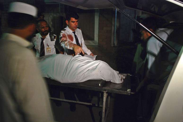 <p>Os membros da tripula&ccedil;&atilde;o de um avi&atilde;o Pakistan International Airlines s&atilde;o vistos ao lado do corpo de uma passageira&nbsp;que n&atilde;o resistiu e morreu&nbsp;em um hospital em Peshawar, em 25 de junho</p>