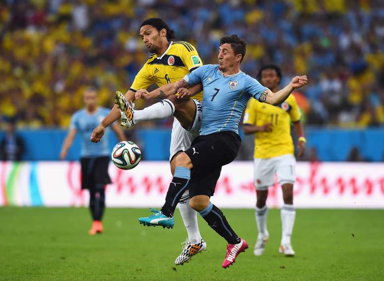 <p>Cristian Rodriguez em dividida de bola no início do jogo Colômbia x Uruguai pelas oitavas de final</p>