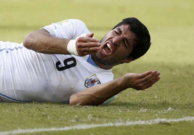 <p>Luis Suarez após morder o italiano Giorgio Chiellini; punição o tirou da Copa e adiou sua estreia no Barcelona </p>