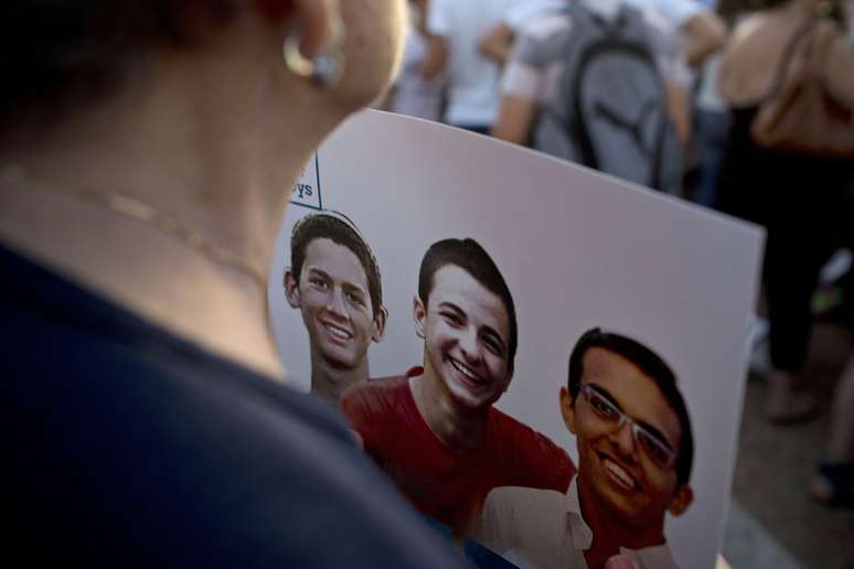 <p>Uma mulher segura um cartaz com a foto dos três adolescentes israelenses sequestrados, durante manifestação em Tel Aviv, em 29 de junho</p>