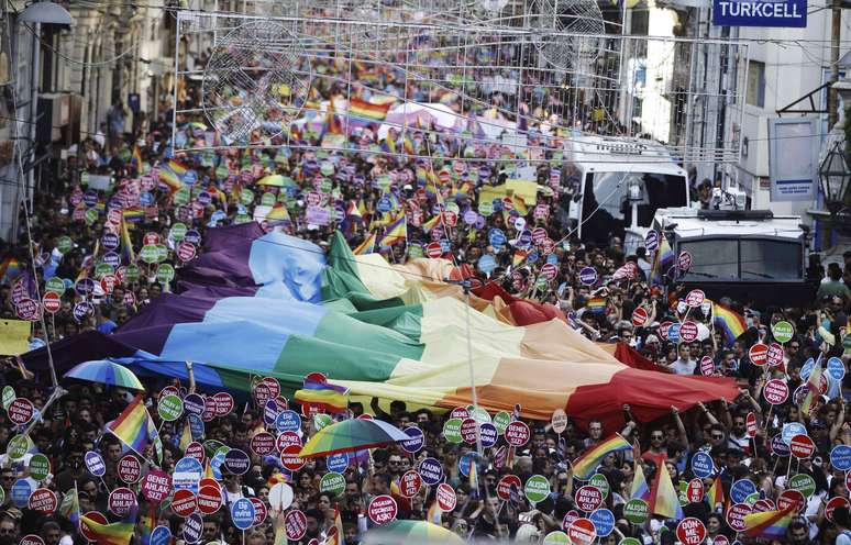 <p>Participantes agitam uma enorme bandeira do arco-íris durante a parada do orgulho gay no centro de Istambul, em 29 de junho</p>