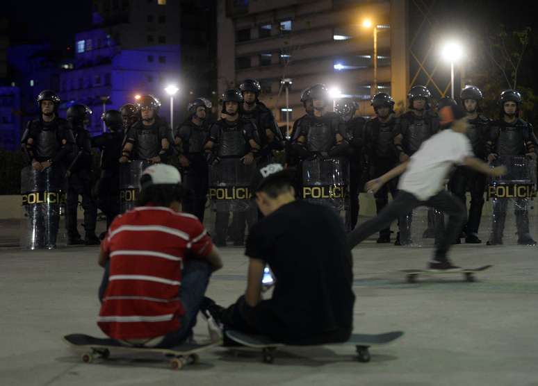 <p>Jovens observam cordão policial durante protesto na praça Roosevelt no último dia 1º de julho</p>