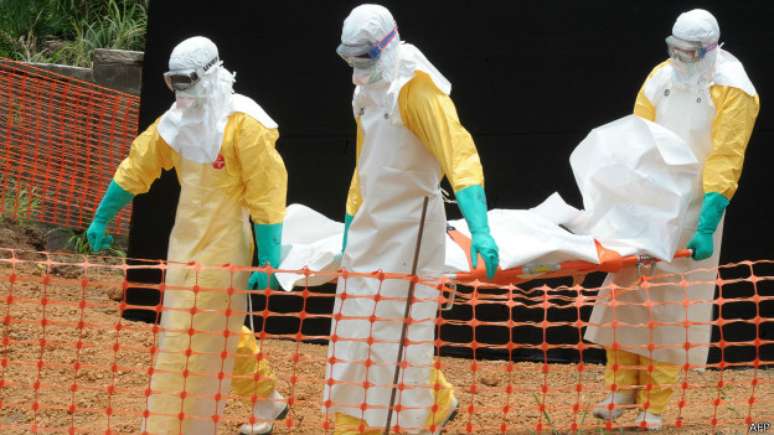 Médicos carregam corpo de vítima do ebola, em Gueckedou, Guiné