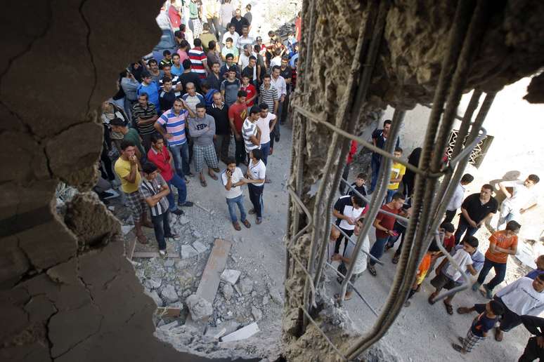 <p>Pessoas observam os escombros da casa do palestino Ziad Awad, na aldeia de Idhna, perto da cidade de Hebron, no sul da Cisjord&acirc;nia, em&nbsp;2 de julho</p>