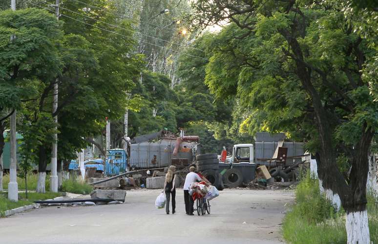 <p>Moradores passam&nbsp;em um checkpoint controlado&nbsp;por separatistas pr&oacute;-R&uacute;ssia, na cidade ucraniana oriental de Slaviansk, em 16 de junho</p>