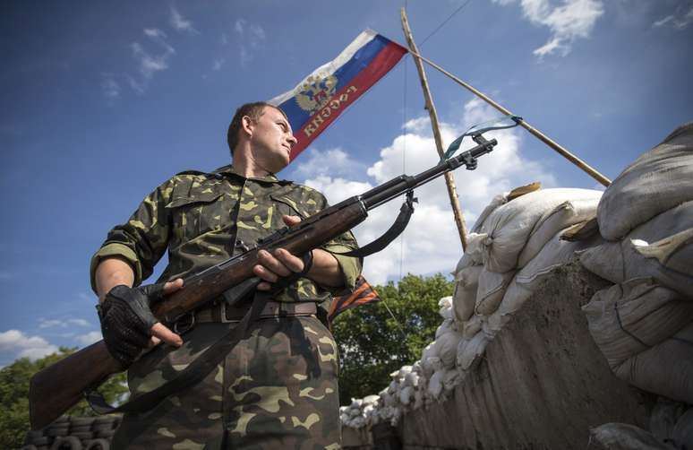 <p>Um separatista pr&oacute;-R&uacute;ssia&nbsp;monta guarda em&nbsp;um posto de controle&nbsp;rodovi&aacute;rio fora da cidade de Lysychansk, na regi&atilde;o de Lugansk, em 24 de junho</p>