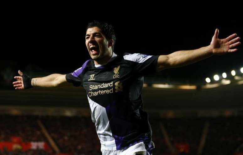 Jogador do Liverpool Luis Suárez comemora gol marcado por seu companheiro de equipe Stirling durante partida contra o Southampton pelo Campeonato Inglês, no estádio St. Mary, em Southampton. 1/03/2014.