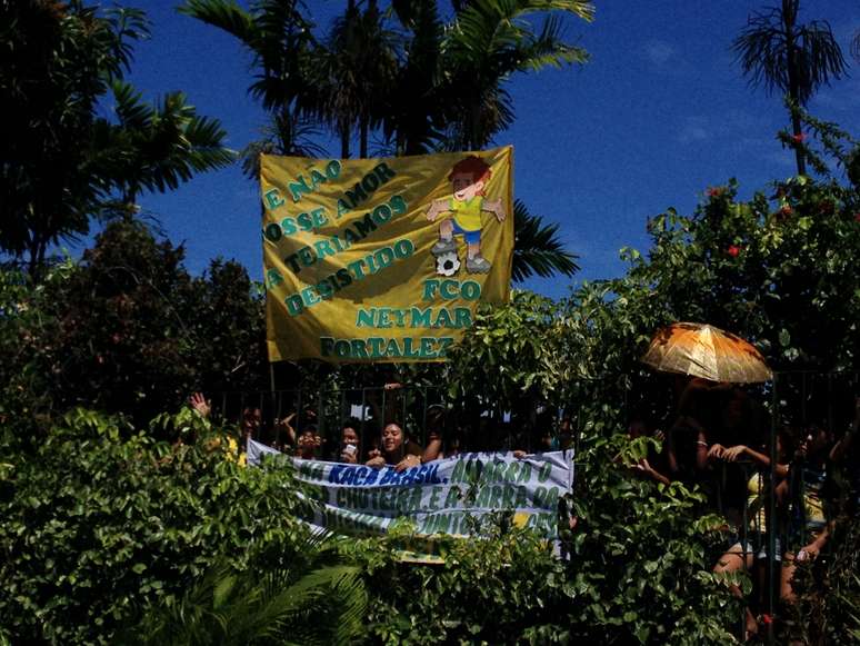Torcedoras entraram em arbusto e se penduraram em grade na expectativa de ver jogadores da Seleção na piscina