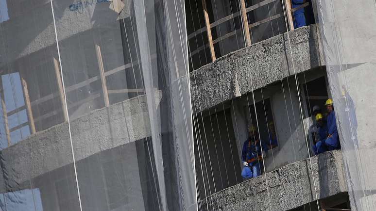 Operários de uma obra próxima ao Estádio Presidente Vargas acompanham o treino da Seleção