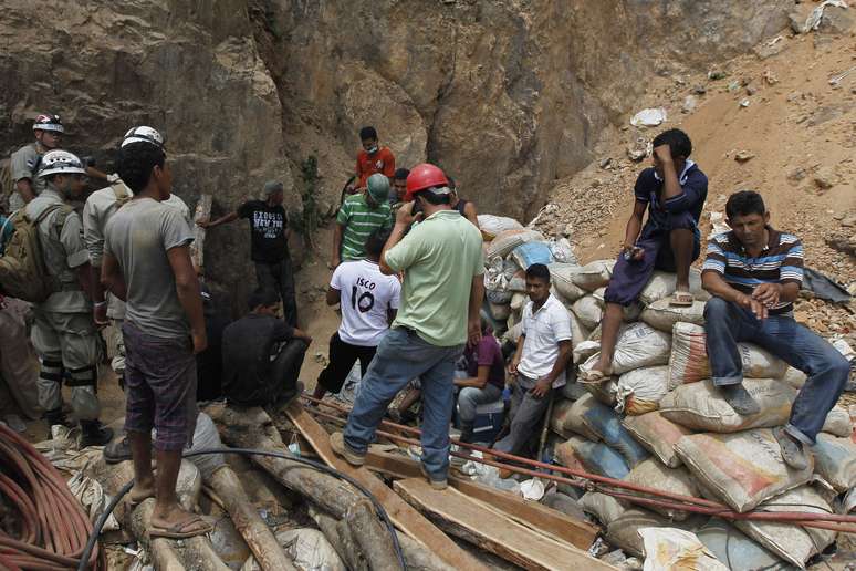 <p>Mineiros e equipes de resgate na entrada de uma mina de ouro bloqueada por um deslizamento de terra em San Juan Arriba</p>