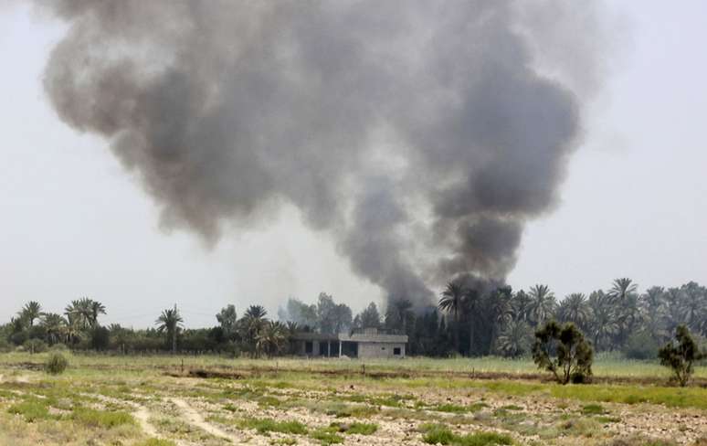 <p>Fumaça causada pelos confrontos entre as forças de segurança iraquianas e militantes do Estado Islâmico na cidade de Dalli Abbas, na província de Diyala</p>
