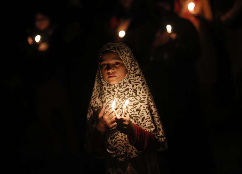 <p>Menina muçulmana xiita participa de um protesto à luz de velas contra o conflito no Iraque, em Nova Delhi. Cerca de 50 enfermeiras indígenas do sul do estado de Kerala foram sequestradas</p>