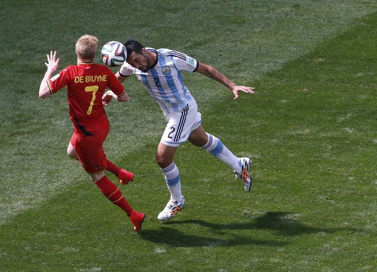 Garay e De Bruyne disputam bola aérea durante jogo entre Bélgica e Argentina