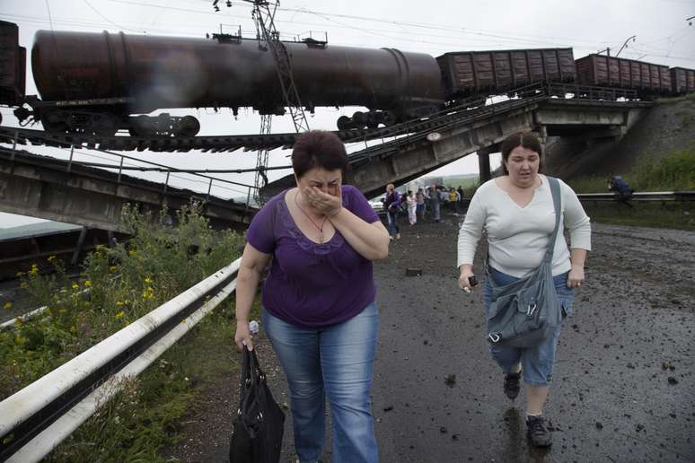 <p>Pessoas caminham por baixo da ponte que liga a cidade de Donetsk a outras, na Ucrânia</p>