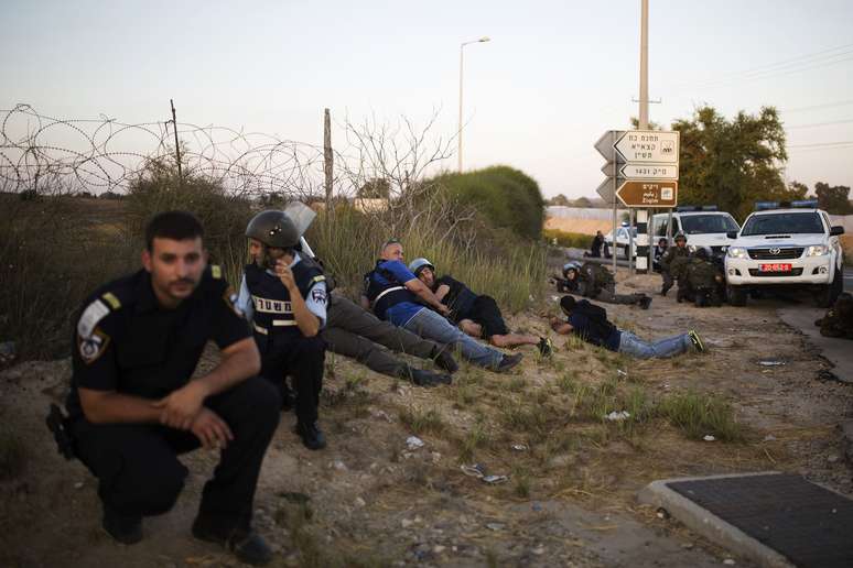 <p>Policiais israelenses se encondem durante infiltra&ccedil;&atilde;o por homens armados do Hamas perto de Kibbutz Zikim</p>