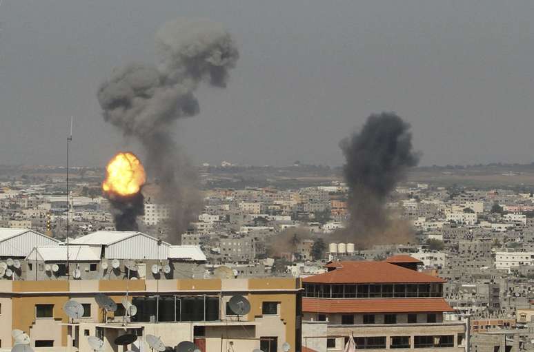 <p>Fumaça e chamas são vistos seguindo o que a polícia disse ter sido um ataque aéreo israelense na cidade de Gaza, nesta terça-feira, 8 de julho</p>