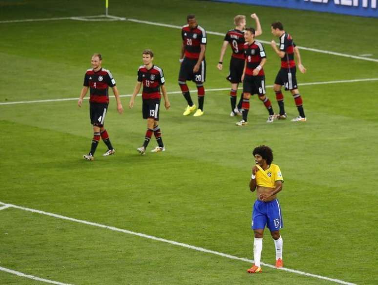 Alemães comemoram gol contra o Brasil enquanto Dante lamenta. 08/07/2014