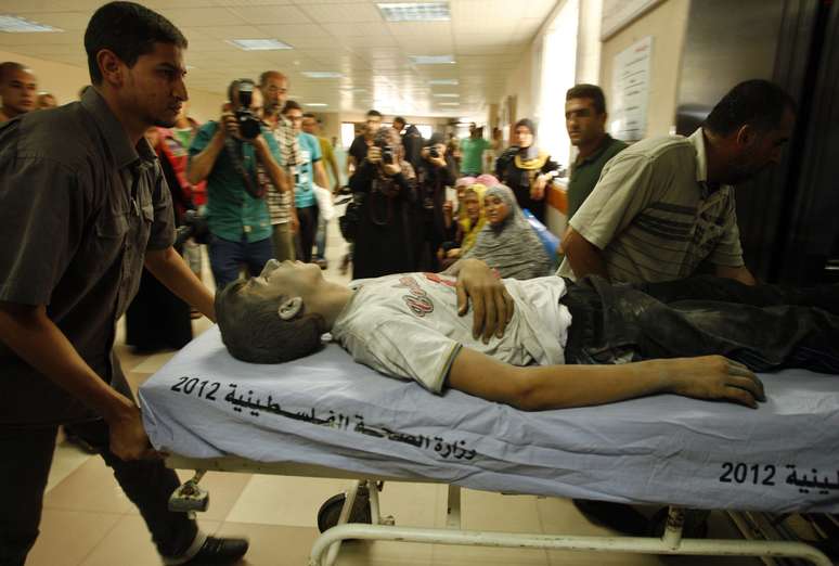 <p>Palestinos socorrem jovem ferido em um ataque a&eacute;reo israelense&nbsp;na Faixa&nbsp;de Gaza, em 9 de julho</p>