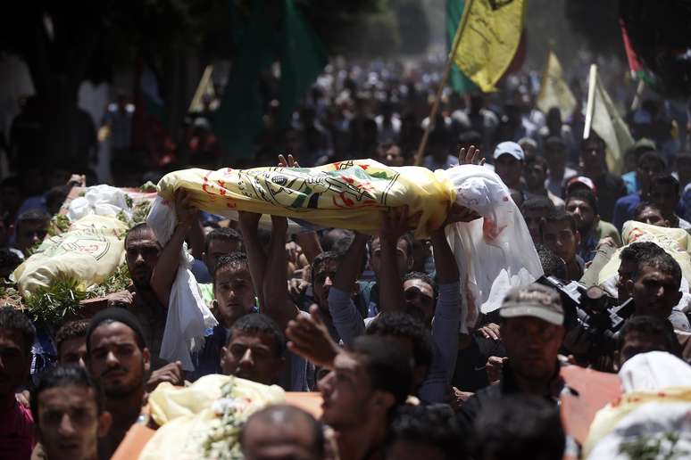 <p>Parentes e amigos da fam&iacute;lia al-Kaware transportam&nbsp;os sete corpos para a mesquita, durante o funeral em Khan Yunis, na Faixa de Gaza, em 9 de julho</p>