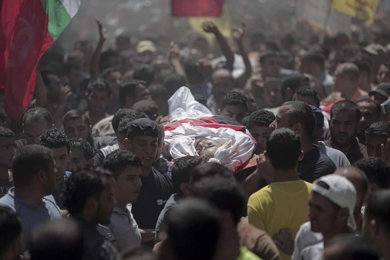 <p>Palestinos carregam o corpo de familiares mortos em um ataque de mísseis israelenses, na cidade de Beit Hanoun, no norte da Faixa de Gaza, em 9 de julho</p>